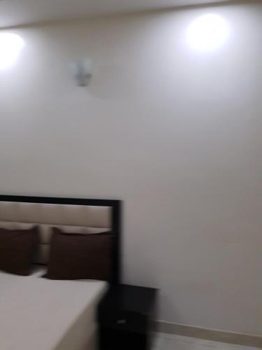 a bedroom with a bed and a white wall at DELIGHTFUL ! 3 BEDROOM TERRACE DUPLEX EN-SUITE ORCHID RD LEKKI AIRCON WiFi in Lagos