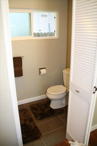 a bathroom with a white toilet and a window at 3 BR Channel House with Dock in Lakeport