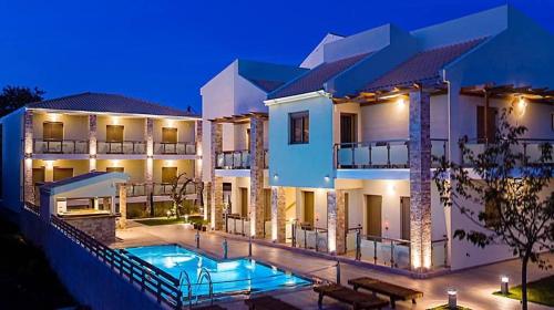 a villa with a swimming pool at night at Melydron Apartments in Preveza