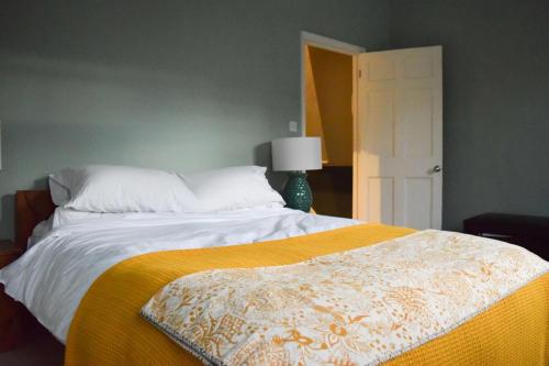 um quarto com uma cama grande e um cobertor amarelo em Stylish and Spacious Apartment with Terrace em Londres