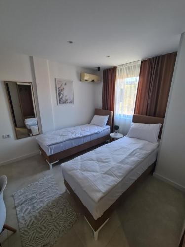 Habitación de hotel con 2 camas y espejo en Glass Apartmani, en Novi Pazar