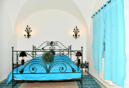 BUNGALOW El HOUDA في الحمامات: غرفة نوم بسرير ازرق وستائر زرقاء