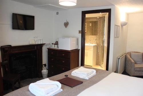 a bedroom with a bed with two towels on it at The George Inn in Castleton