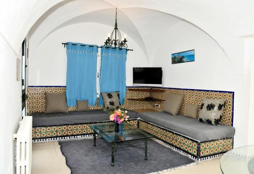 uma sala de estar com dois sofás e uma mesa em BUNGALOW El HOUDA em Hammamet