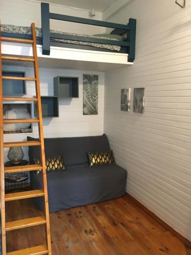 - un canapé dans une chambre avec une échelle et des lits superposés dans l'établissement Petit studio, plein centre ville, grande terrasse, à Bagnères-de-Bigorre