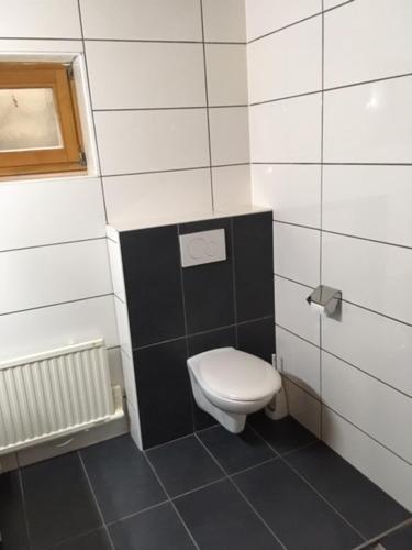 a bathroom with a toilet in a black and white wall at Haus ter Stege in Annaberg im Lammertal