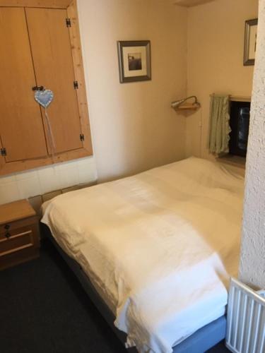 a bedroom with a white bed and a cabinet at Haus ter Stege in Annaberg im Lammertal