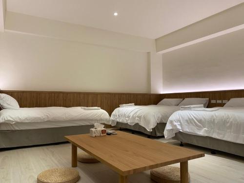 An An Homestay في شينتشنغ: غرفة بسريرين وطاولة خشبية