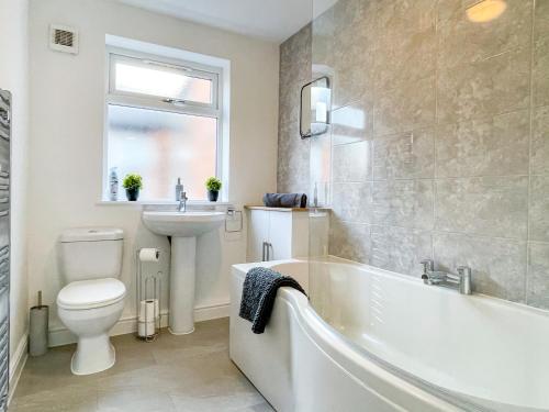 a bathroom with a tub and a toilet and a sink at Spacious 2-bed Apartment in Crewe by 53 Degrees Property, ideal for Business & Professionals, FREE Parking - Sleeps 3 in Crewe