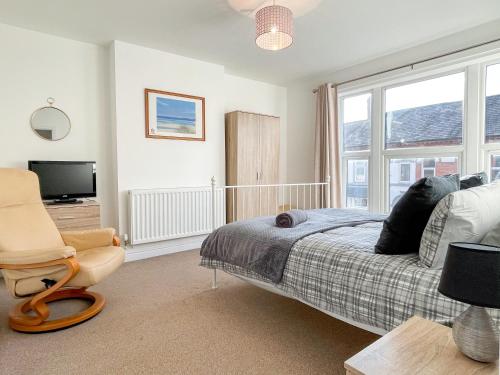 克魯的住宿－Spacious 2-bed Apartment in Crewe by 53 Degrees Property, ideal for Business & Professionals, FREE Parking - Sleeps 3，卧室配有床、椅子和窗户。
