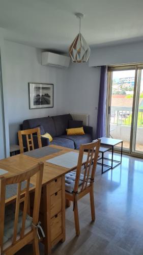 un salon avec une table, des chaises et un canapé dans l'établissement 2P entièrement climatisé I Bien insonorisé I Wifi I A 300 m de la mer I Restaurants commerces et transports à 5mn à pied I Idéal 2 personnes I Possibilité 4 avec canapé lit de qualité I Très belle Douche, à Cagnes-sur-Mer