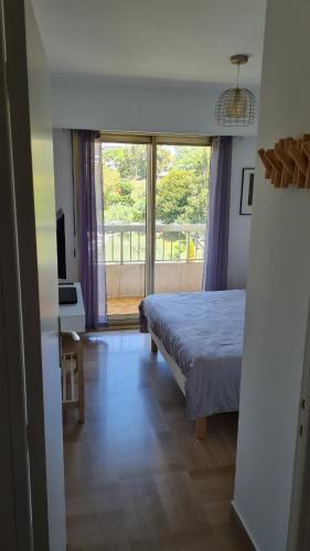 une chambre avec un lit et une grande fenêtre dans l'établissement 2P entièrement climatisé I Bien insonorisé I Wifi I A 300 m de la mer I Restaurants commerces et transports à 5mn à pied I Idéal 2 personnes I Possibilité 4 avec canapé lit de qualité I Très belle Douche, à Cagnes-sur-Mer