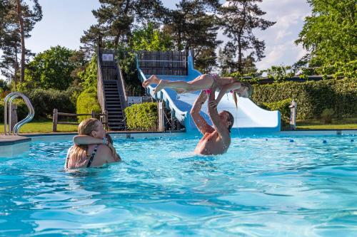 a man and a woman in a swimming pool at Resort Veluwe in Garderen