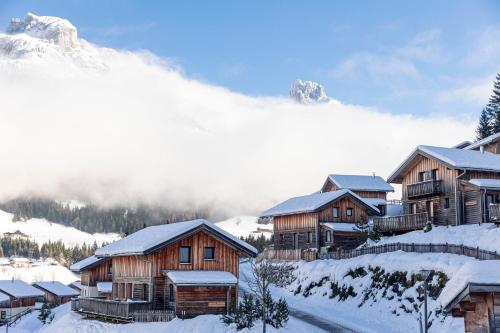 a group of wooden cabins in the snow at Alpendorf Dachstein West by ALPS RESORTS in Annaberg im Lammertal