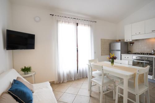 sala de estar con mesa y cocina en Villa del Porto La Terrazza, en Portoscuso