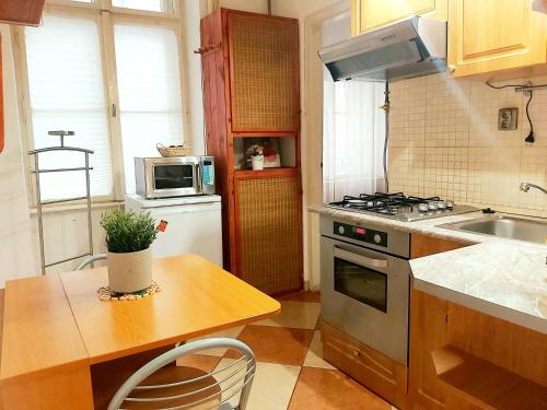 een keuken met een tafel en een fornuis top oven bij FERJOE'S HOME APARTMAN in Boedapest