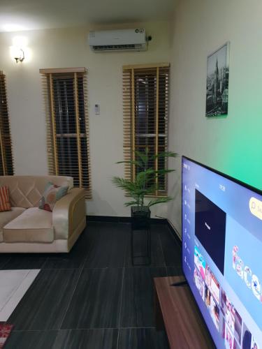 a living room with a large flat screen tv at NESTAPARTMENTS , Orchid Road , VAN DANIEL'S STREET, LEKKI , Ensuite ,WiFi in Lagos