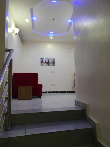 a room with a red couch and a white wall at NESTAPARTMENTS , Orchid Road , VAN DANIEL'S STREET, LEKKI , Ensuite ,WiFi in Lagos