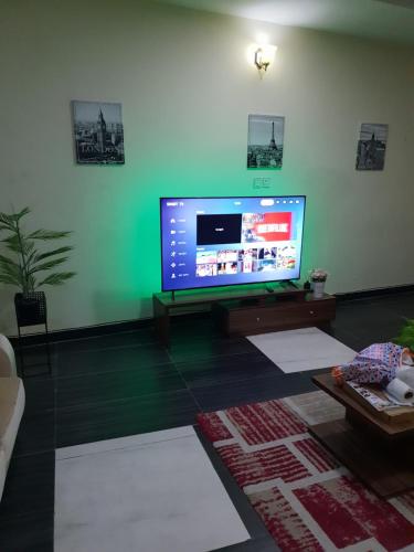 a living room with a large flat screen tv at NESTAPARTMENTS , Orchid Road , VAN DANIEL'S STREET, LEKKI , Ensuite ,WiFi in Lagos