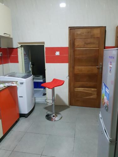 a red stool in a kitchen with a door at NESTAPARTMENTS , Orchid Road , VAN DANIEL'S STREET, LEKKI , Ensuite ,WiFi in Lagos