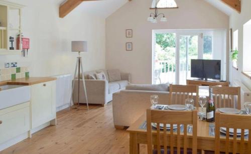 a kitchen and living room with a table and chairs at Wild Coastal Retreat at Troed Y Rhiw Aberporth in Aberporth