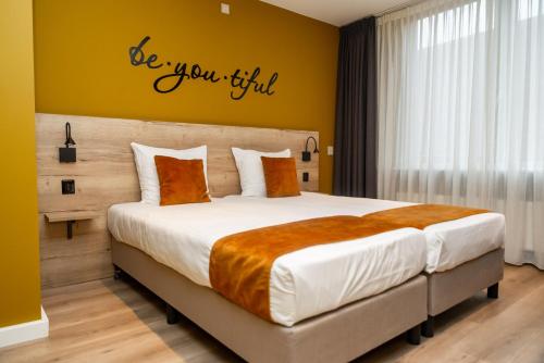 una camera con un letto con un sipario ancora firmi sul muro di Hotel Onder De Linden a Roden