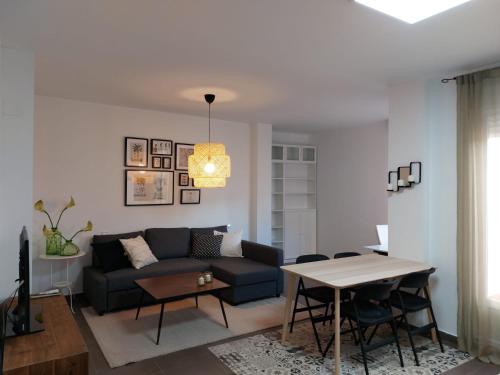 ein Wohnzimmer mit einem Sofa und einem Tisch in der Unterkunft Apartamento JALAMA 1D in Moraleja