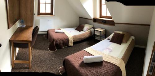 a hotel room with two beds and a desk at Domy całoroczne Osada na Górce in Ustrzyki Dolne