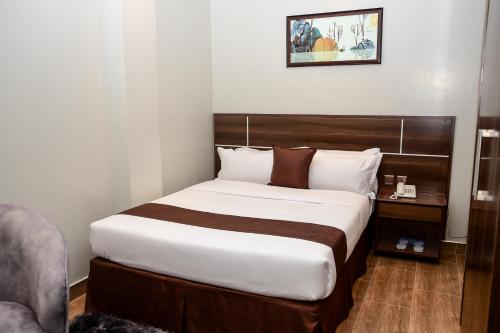 a bedroom with a large bed with a wooden headboard at LA BEILA HOTEL MERU in Meru