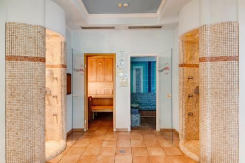 a bathroom with tiled walls and a toilet in a room at Smy Koflerhof Wellness & Spa Dolomiti in Rasun di Sopra