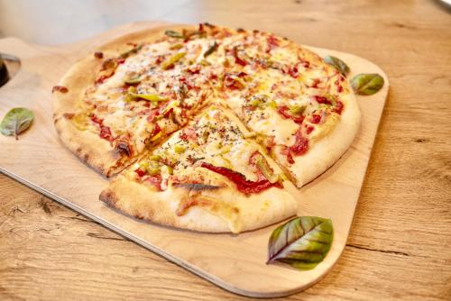 a pizza sitting on top of a wooden cutting board at ibis Budget Colmar Centre Gare in Colmar