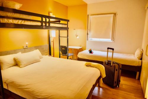a bedroom with two bunk beds and a suitcase at ibis Budget Colmar Centre Gare in Colmar
