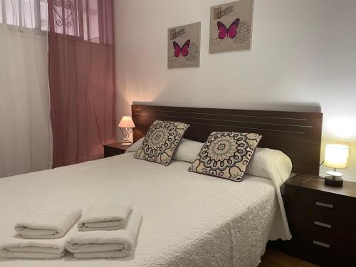 1 dormitorio con 1 cama con 2 almohadas y mariposas en la pared en Playa Honda Lovely Home Las Americas -, en Playa de las Américas