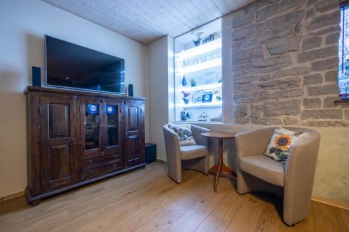 a living room with a tv and a table and chairs at Saue 1 Apartment in Tallinn