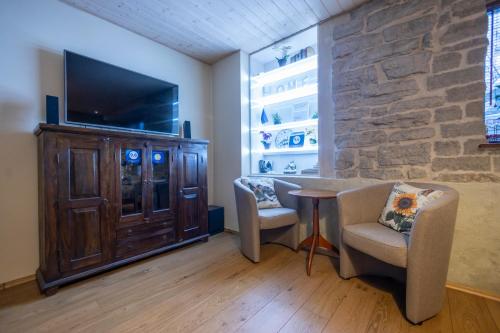 Una sala de estar con televisión, mesa y sillas. en Saue 1 Apartment, en Tallin