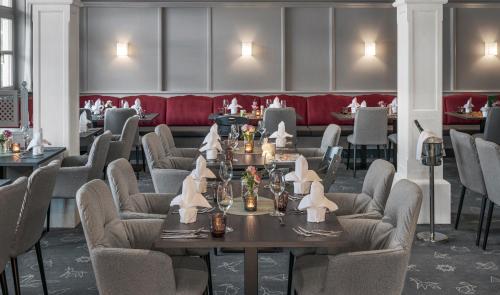 a restaurant with tables and chairs and a red couch at Lisi Family Hotel in Reith bei Kitzbühel