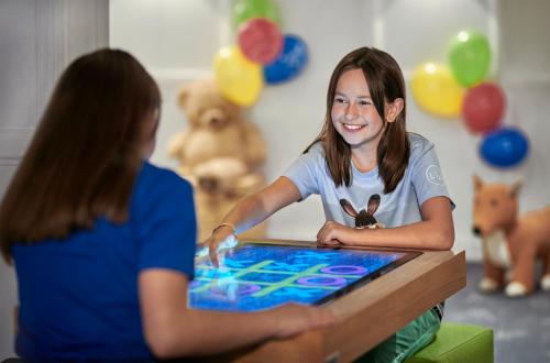 two girls sitting at a table playing a game at Lisi Family Hotel in Reith bei Kitzbühel