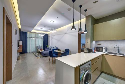 a kitchen and living room with a washer at ABAR HOTEL APARTMENTS DIP-1 in Dubai