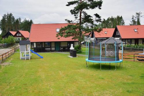 une cour avec 2 balançoires et une aire de jeux dans l'établissement Pastelowy Domek, à Załakowo