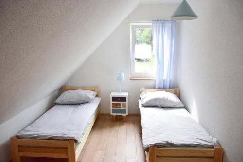 - 2 lits jumeaux dans une chambre avec fenêtre dans l'établissement Pastelowy Domek, à Załakowo