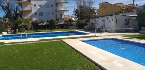 a swimming pool in a yard next to a building at Apartamento en la milla de oro, a 100m de la playa in Marbella