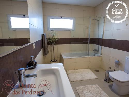 uma casa de banho com uma banheira, um WC e um lavatório. em Quinta das Perdizes em Ponta Delgada