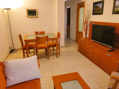 un soggiorno con divano, tavolo e TV di Centro cerca playa a Benidorm