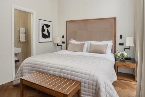 a bedroom with a large bed and a wooden table at The Queens Gate Hotel in London