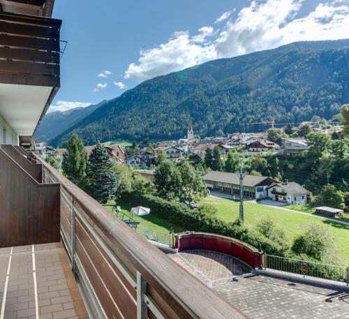 a balcony with a view of a town and mountains at Smy Koflerhof Wellness & Spa Dolomiti in Rasun di Sopra