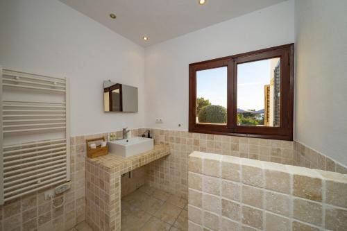 a bathroom with a sink and a window at Villa Nubita in Sant Josep de Sa Talaia
