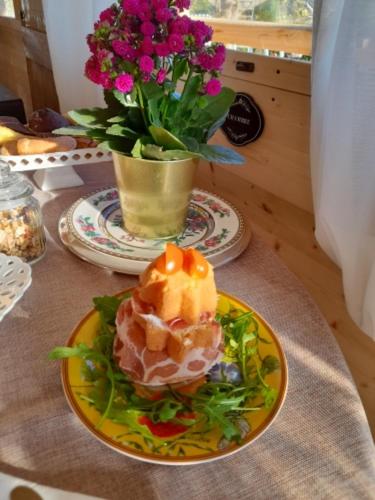 a plate of food on a table with a vase of flowers at B&B Luxury Villa Olimpia Home Restaurant in Selva di Fasano