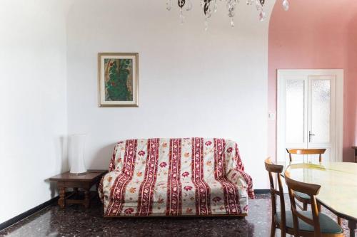 een woonkamer met een bank en een tafel bij Le Finestre sul Mare in Albissola Marina