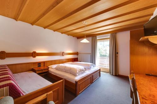 a bedroom with two beds in a room with a window at Smy Koflerhof Wellness & Spa Dolomiti in Rasun di Sopra