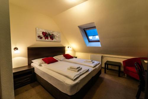 a bedroom with a large bed with a window at Hotel Koruna Prachatice in Prachatice